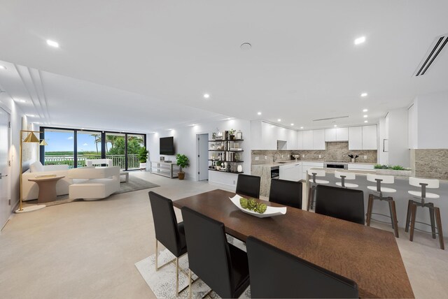 kitchen with sink, white cabinetry, stainless steel appliances, light stone counters, and kitchen peninsula