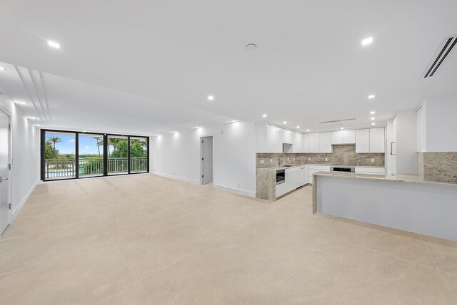 kitchen with white cabinetry, appliances with stainless steel finishes, sink, and light stone counters