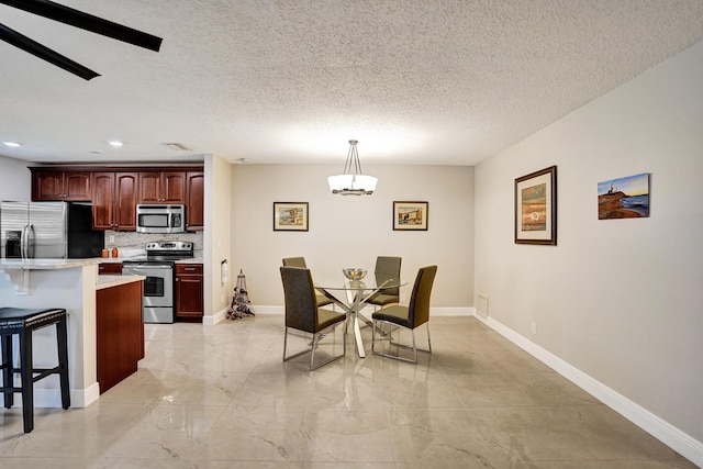 dining area with a textured ceiling and ceiling fan