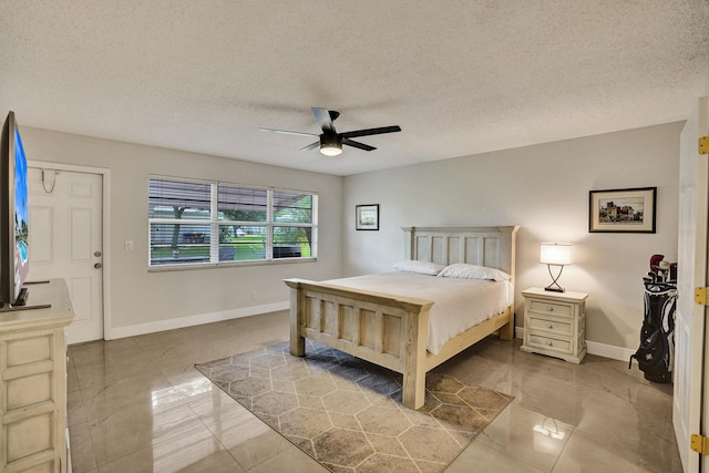 bedroom with ceiling fan and a textured ceiling