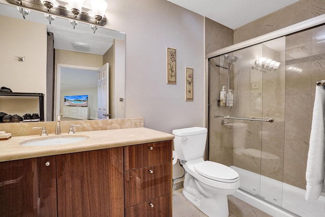 bathroom with toilet, a shower with shower door, and vanity