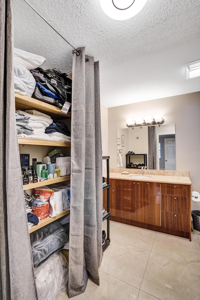 bathroom with vanity, tile patterned flooring, and a textured ceiling