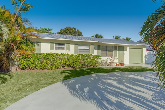 ranch-style house featuring a front lawn and a garage