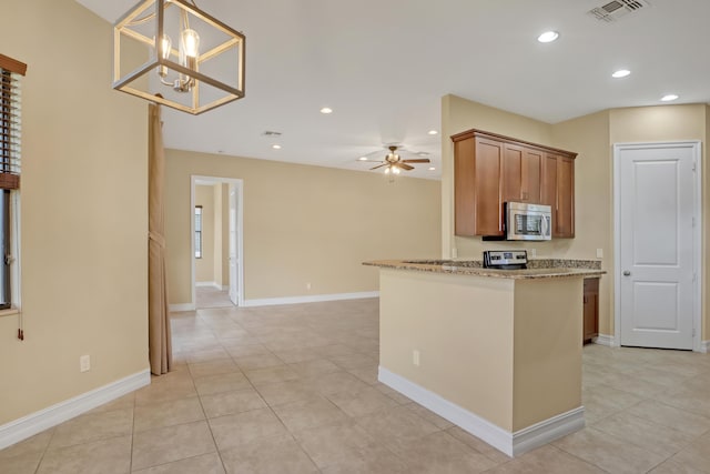 kitchen with kitchen peninsula, appliances with stainless steel finishes, hanging light fixtures, ceiling fan with notable chandelier, and light stone counters