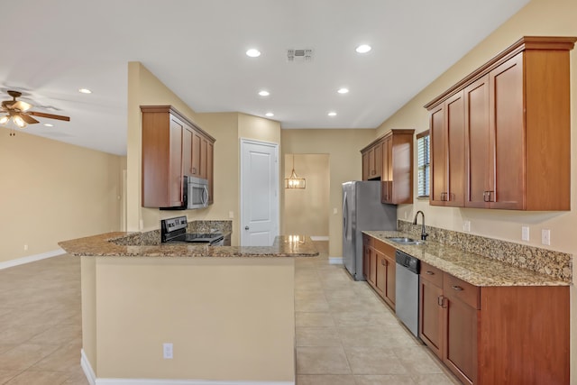 kitchen with kitchen peninsula, ceiling fan, appliances with stainless steel finishes, stone countertops, and sink