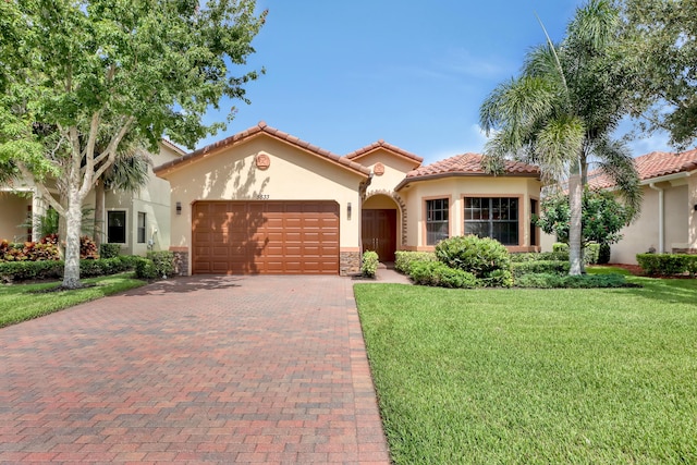 mediterranean / spanish-style home featuring a front lawn and a garage