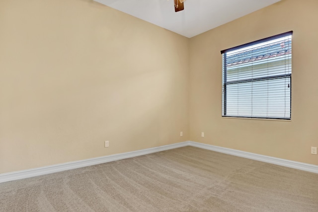 empty room featuring carpet floors and ceiling fan