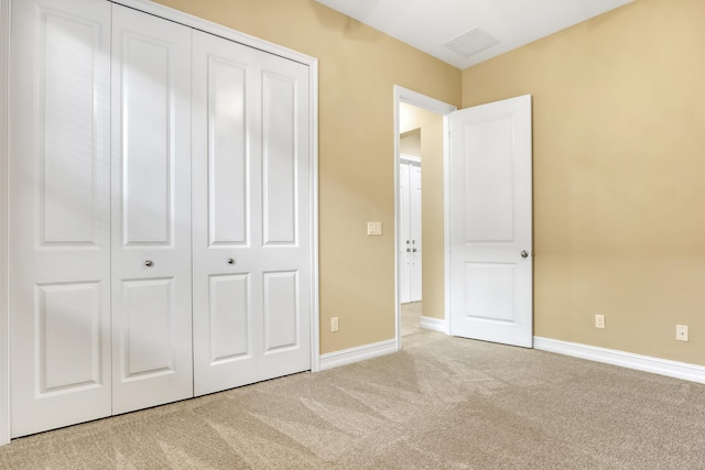 unfurnished bedroom with light carpet and a closet