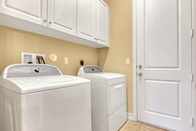 laundry area with cabinets, light tile patterned floors, and independent washer and dryer