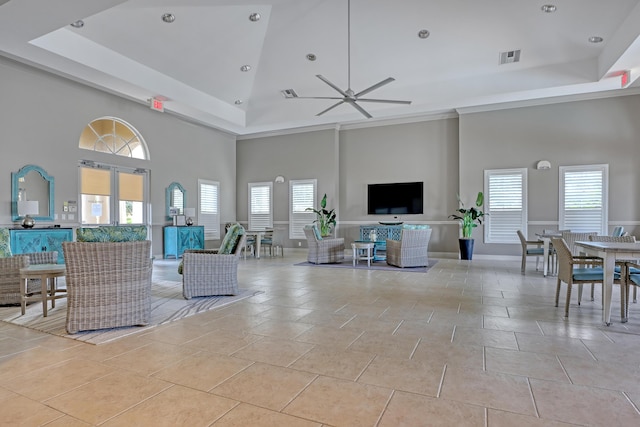 tiled living room featuring ceiling fan and a high ceiling