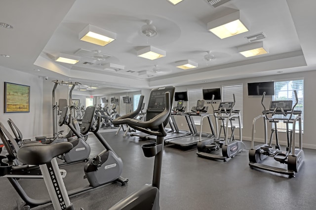 gym with a raised ceiling and ceiling fan