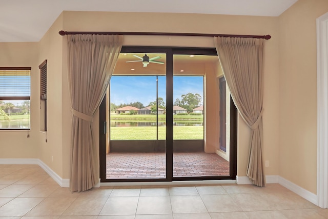 doorway with ceiling fan and light tile patterned flooring