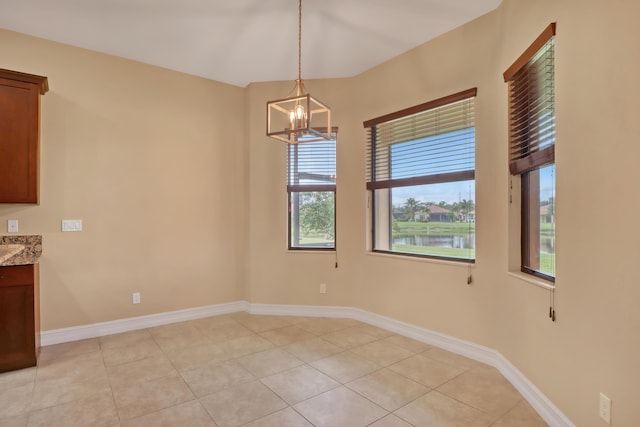 unfurnished room featuring an inviting chandelier and light tile patterned flooring