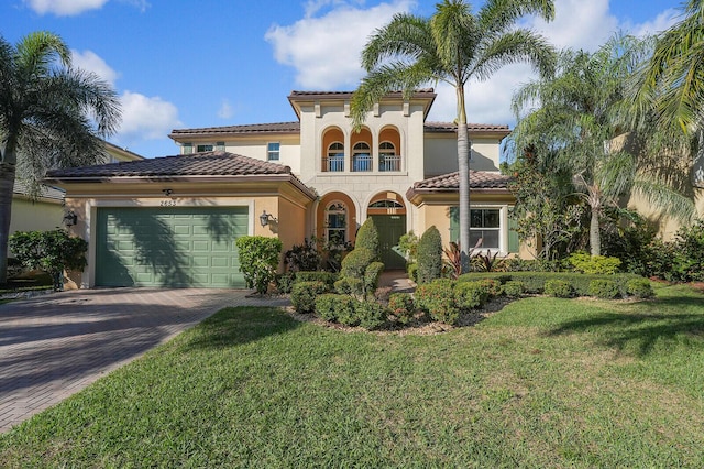 mediterranean / spanish house featuring a garage and a front yard