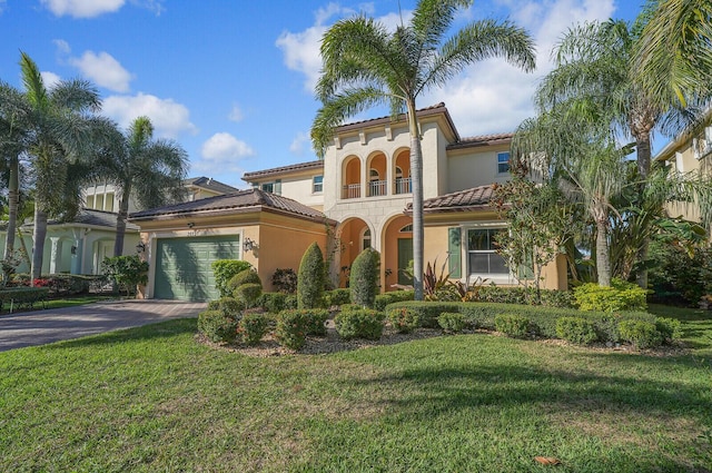 mediterranean / spanish-style home with a garage, a front yard, and a balcony