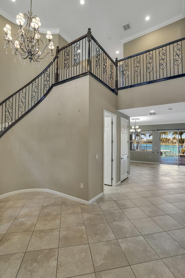 staircase featuring an inviting chandelier, tile patterned floors, ornamental molding, and a high ceiling