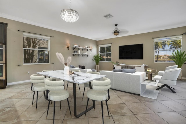 dining space featuring light tile patterned floors, crown molding, and a notable chandelier