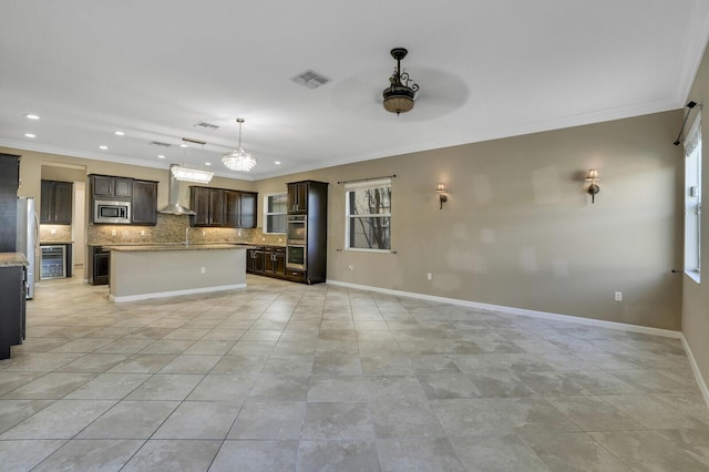 kitchen with dark brown cabinetry, wall chimney exhaust hood, a center island, and decorative backsplash