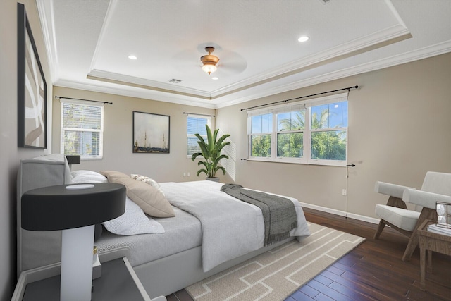 bedroom featuring a tray ceiling, dark wood-type flooring, ornamental molding, and ceiling fan