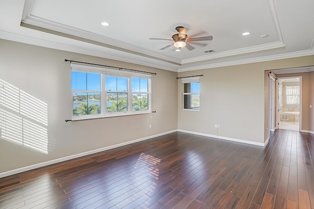 spare room featuring dark hardwood / wood-style flooring, a tray ceiling, ornamental molding, and ceiling fan