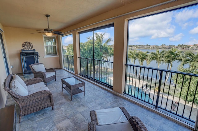 sunroom featuring a water view