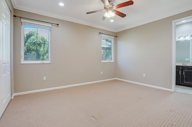 carpeted spare room with ornamental molding, a wealth of natural light, and ceiling fan