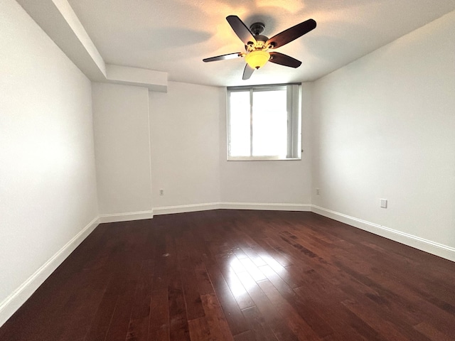 empty room featuring ceiling fan and dark hardwood / wood-style flooring