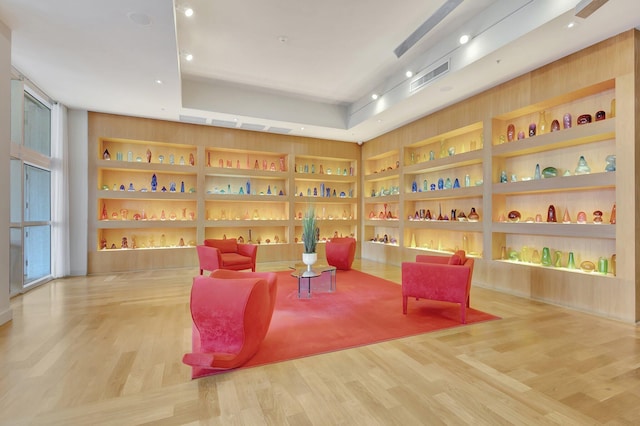 game room featuring light hardwood / wood-style floors, a wealth of natural light, and a tray ceiling