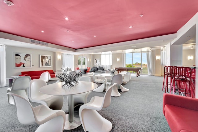 dining area with a tray ceiling, light colored carpet, and billiards