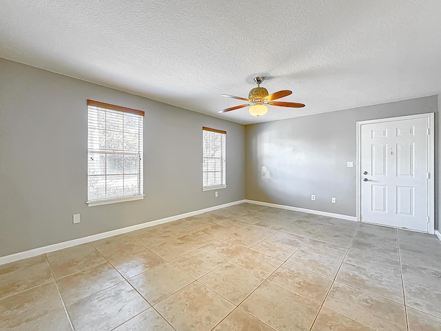 unfurnished room featuring a textured ceiling, ceiling fan, and light tile patterned floors