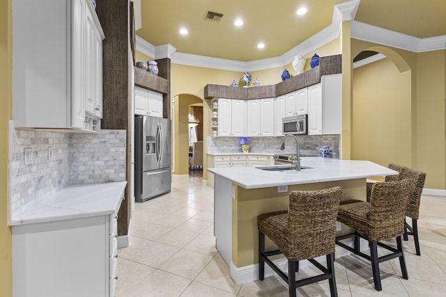 kitchen featuring white cabinetry, a kitchen bar, kitchen peninsula, appliances with stainless steel finishes, and sink