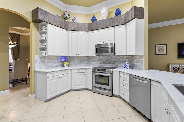 kitchen with light tile patterned flooring, white cabinets, stainless steel appliances, and tasteful backsplash