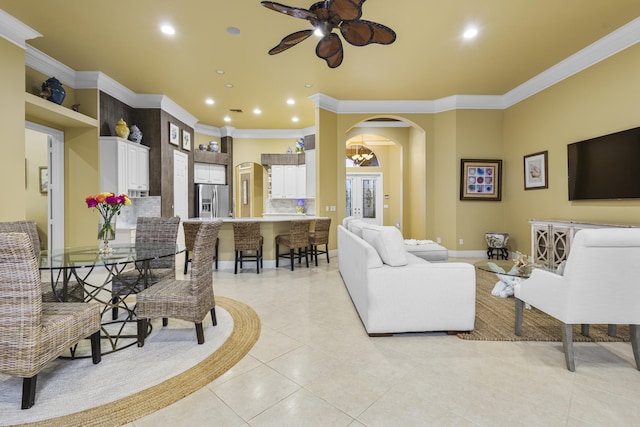 tiled living room with ceiling fan and ornamental molding