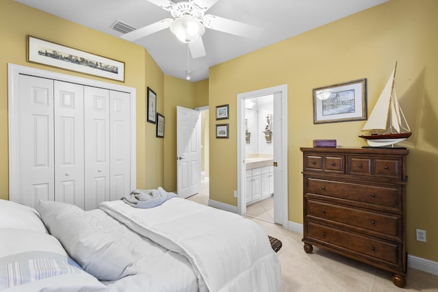 bedroom with light tile patterned flooring, a closet, ensuite bathroom, and ceiling fan