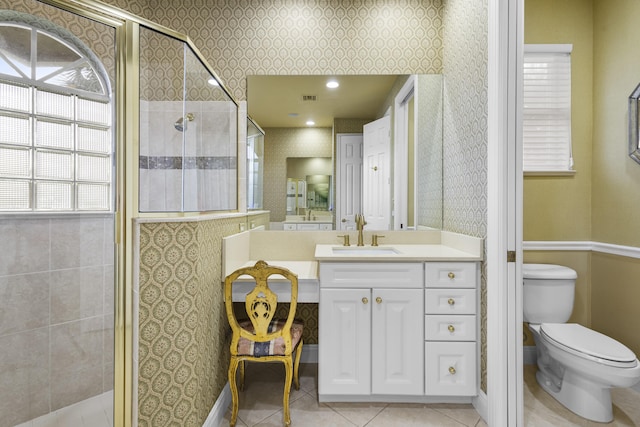 bathroom featuring toilet, tile patterned floors, walk in shower, and vanity