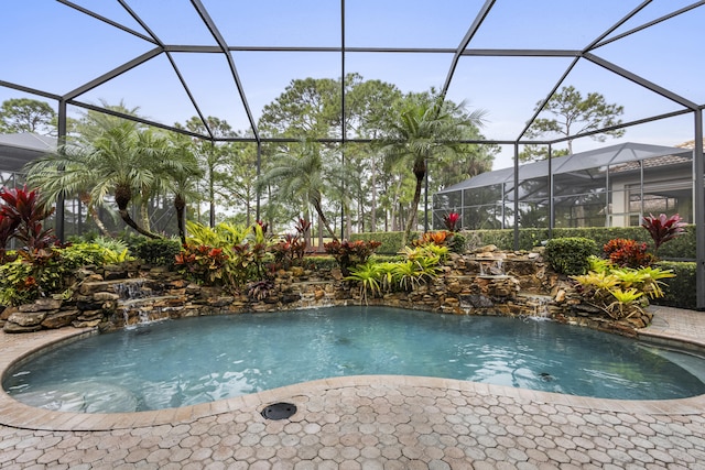 view of swimming pool with pool water feature and a lanai