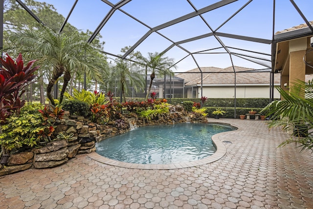 view of pool featuring pool water feature, glass enclosure, and a patio