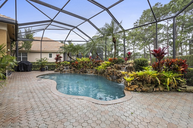 view of swimming pool with a patio area, a lanai, a grill, and pool water feature