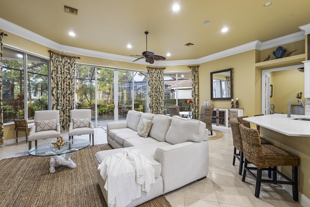 living room with ceiling fan, sink, light tile patterned floors, and ornamental molding