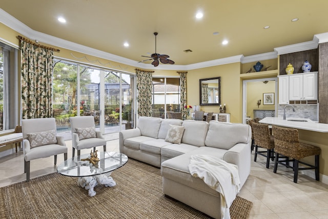 living room featuring light tile patterned flooring, ceiling fan, ornamental molding, and sink