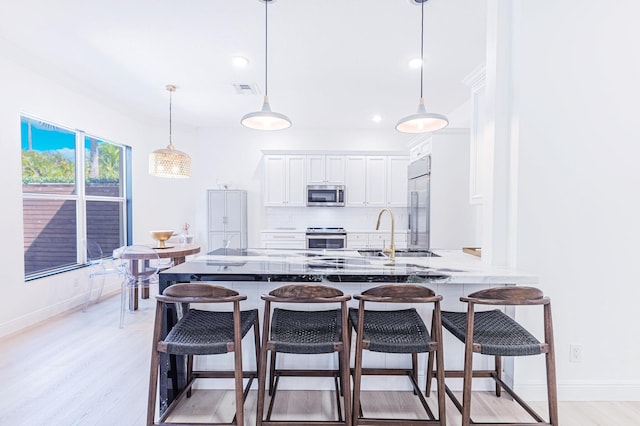 kitchen featuring appliances with stainless steel finishes, kitchen peninsula, decorative backsplash, sink, and white cabinetry