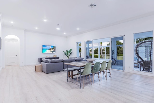 dining area featuring french doors, light wood-type flooring, and crown molding