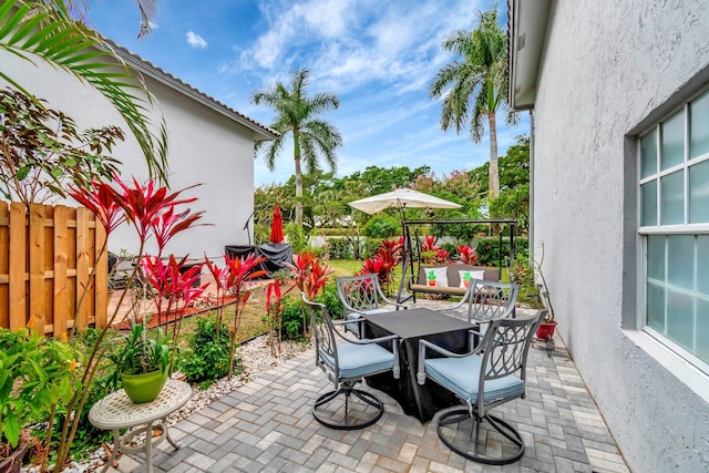 view of patio with outdoor dining space and fence