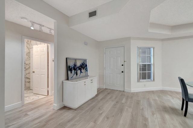 entrance foyer with visible vents, baseboards, track lighting, and light wood-style floors