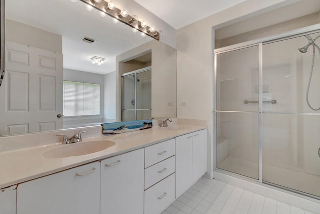 full bath featuring double vanity, visible vents, a shower stall, and a sink