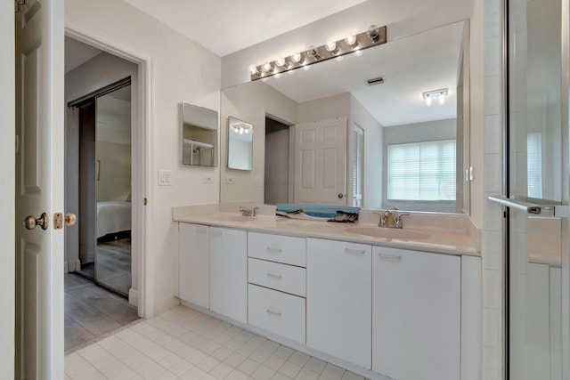 ensuite bathroom featuring double vanity, tile patterned floors, ensuite bath, and a sink