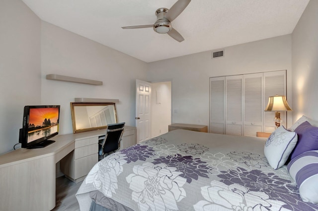 bedroom with visible vents, wood finished floors, a closet, ceiling fan, and built in study area