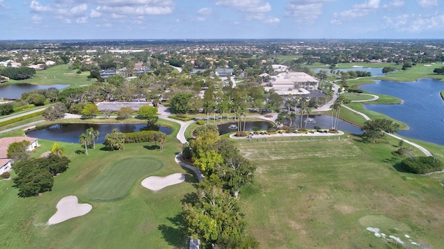 birds eye view of property with view of golf course and a water view