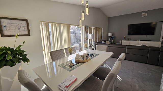 dining space featuring vaulted ceiling