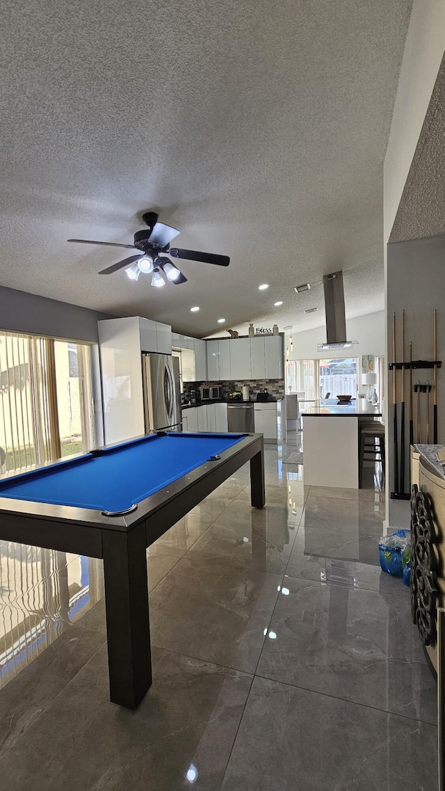 recreation room with pool table, ceiling fan, and a textured ceiling